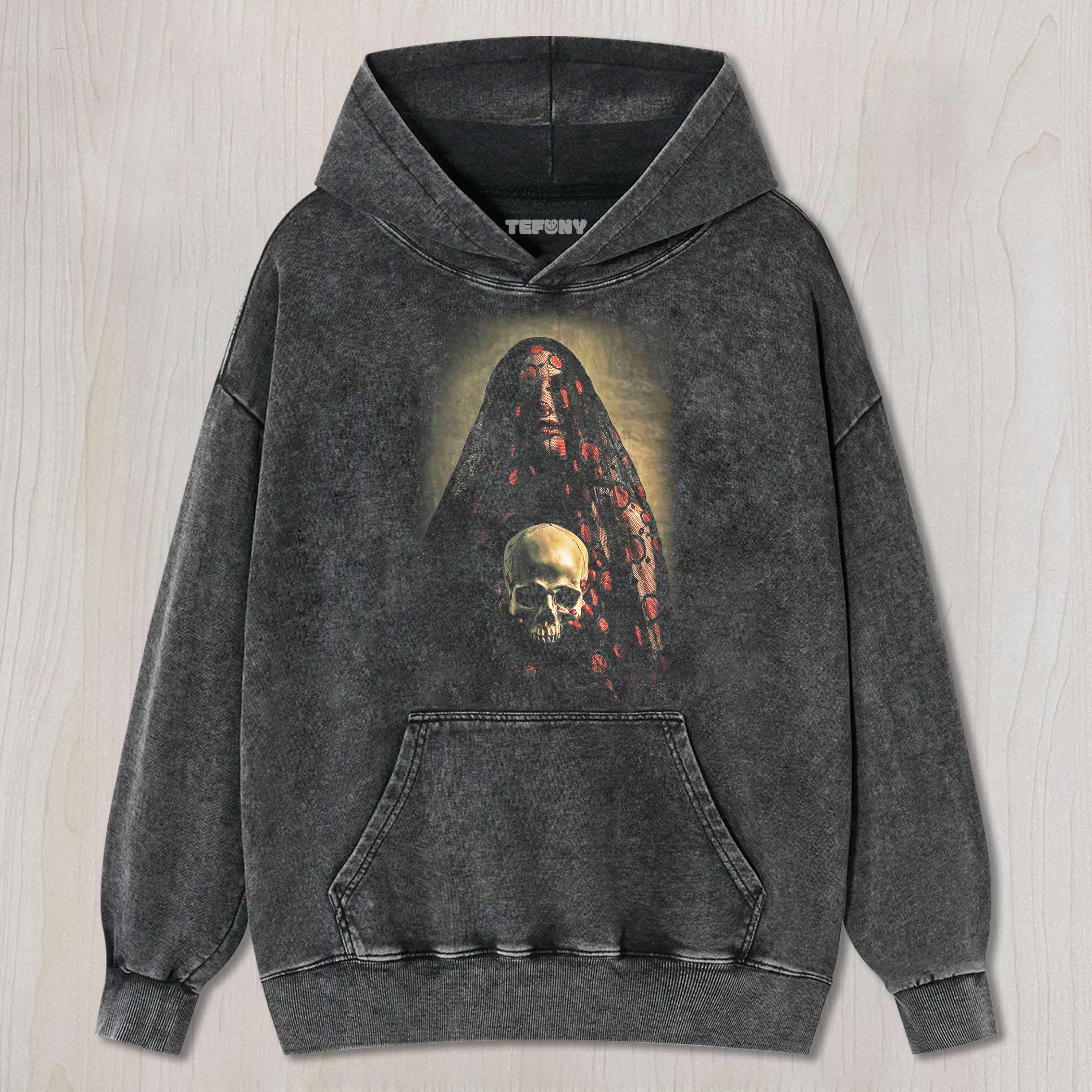 THE BRIDE, VEILED IN LACE, IS HOLDING A SKULL T-SHIRT